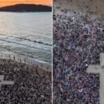 Multidão se reúne em praia de SC para ato de fé.